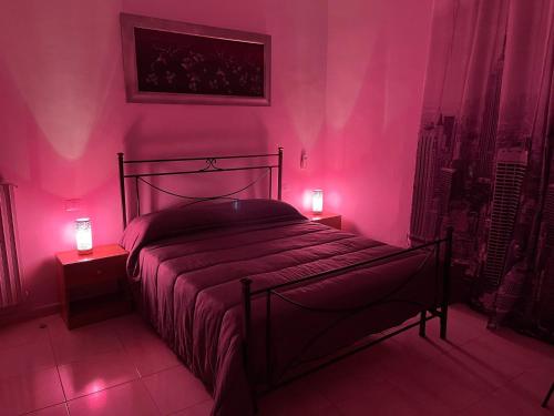 a bedroom with a bed with pink lights on it at Station's Room in Avellino