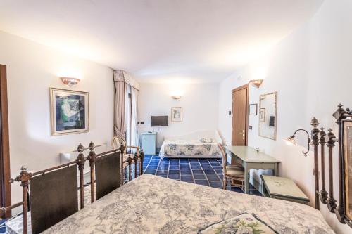 sypialnia z 2 łóżkami, stołem i biurkiem w obiekcie Masseria Ruri Pulcra w mieście Patù