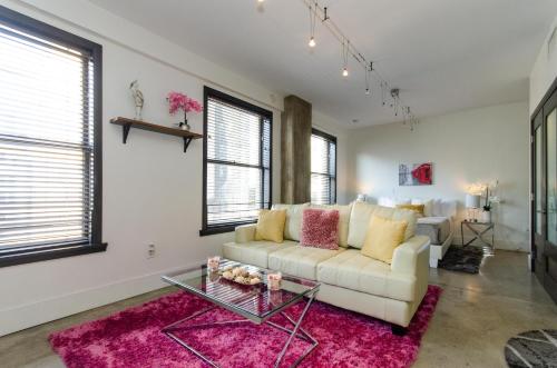 sala de estar con sofá blanco y mesa de cristal en Modern Loft with Rooftop Lounge in DTLA en Los Ángeles