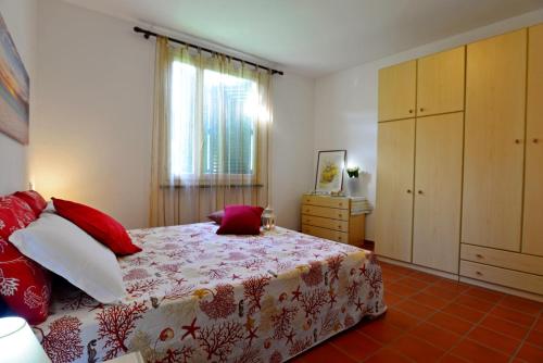 een slaapkamer met een bed, een dressoir en een raam bij Appartamento La Fenicia in Marciana Marina