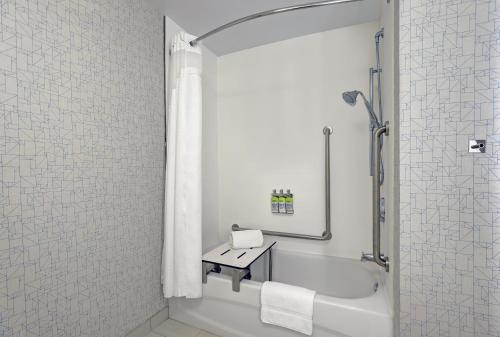 a white bathroom with a tub and a sink at Holiday Inn Express - Kingston West by IHG in Kingston