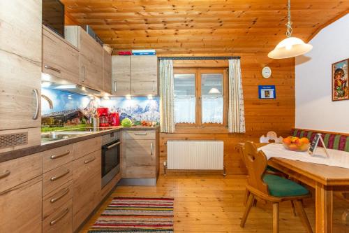 eine Küche mit Holzschränken und einem Holztisch in der Unterkunft Frühstückspension Müllergut in Sankt Martin bei Lofer