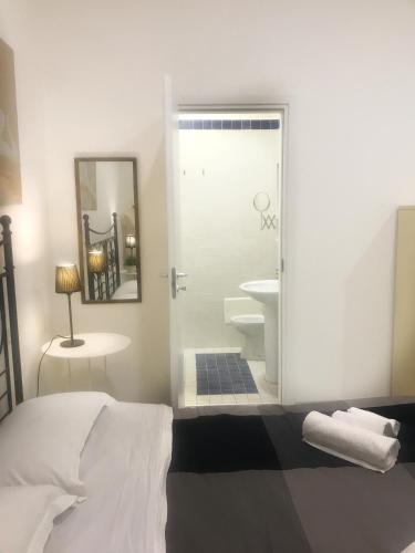 a bedroom with a bed and a bathroom with a shower at Home La Corte in SantʼAntimo