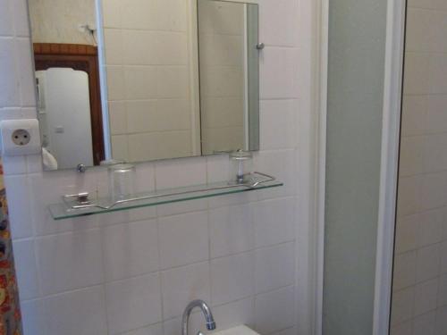 a bathroom with a toilet, sink and mirror at Hotel d'Orléans Paris Gare de l'Est in Paris