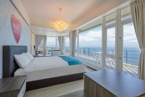 a bedroom with a bed and a balcony with the ocean at Ferry of Love Homestay in Shimen
