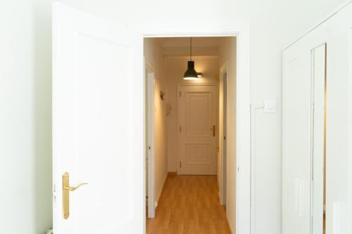a hallway with white walls and a white door at Sweet Home, Cuatro Caminos in A Coruña
