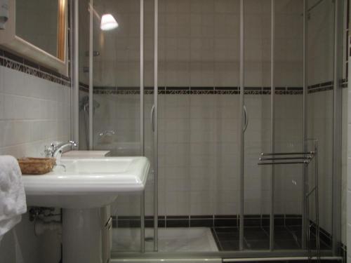 a bathroom with a sink and a glass shower at Hostal Beti-jai in Aoiz