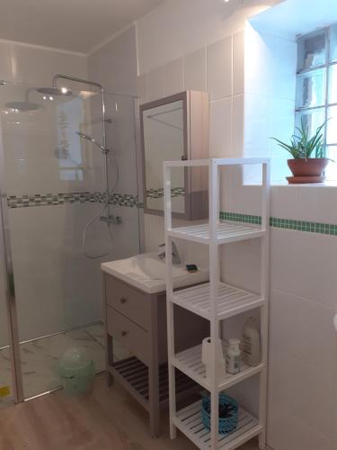 a white bathroom with a sink and a mirror at Les Gites de Kerdurod in Guidel