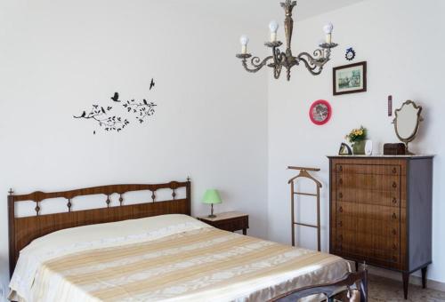 a bedroom with a bed and a dresser and a chandelier at 4 bedrooms apartement with furnished terrace and wifi at Recanati 8 km away from the beach in Recanati
