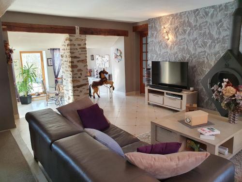 un salon avec un canapé et une télévision dans l'établissement La maison du Fargis, à Auffargis