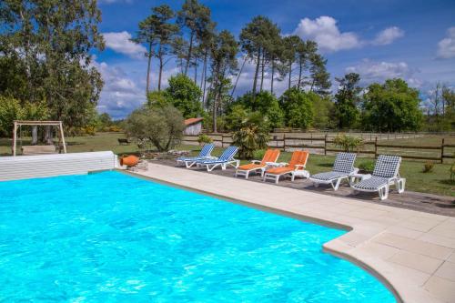 - une piscine avec des chaises longues bleues et oranges dans l'établissement LE GAHOUN - Chalet, à Castets