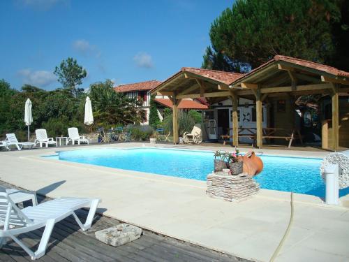 - une piscine avec un kiosque et une maison dans l'établissement LE GAHOUN - Chalet, à Castets