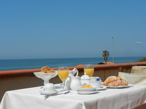 a table with a plate of food and glasses of orange juice at Hotel Villa Maremonti in Marina di Massa