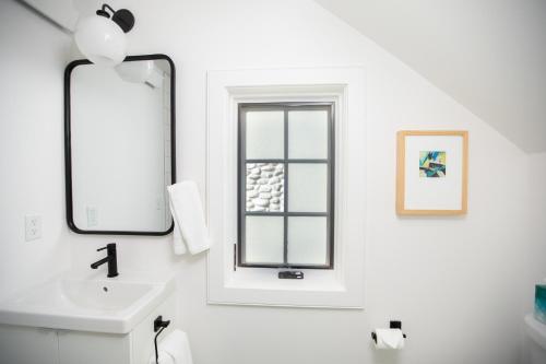 a white bathroom with a sink and a mirror at South Main Residences by Surf Hotel in Buena Vista