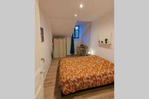 een slaapkamer met een bed in een kamer bij Appart'Hôtel Le Strasbourg - RENOVÉ, CALME ET NETFLIX in Belfort