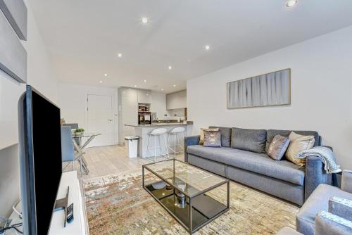 ein Wohnzimmer mit einem Sofa und einem Tisch in der Unterkunft St Martins House Luxury 2 Bedroom Apartments Ruislip By 360Stays in Ruislip