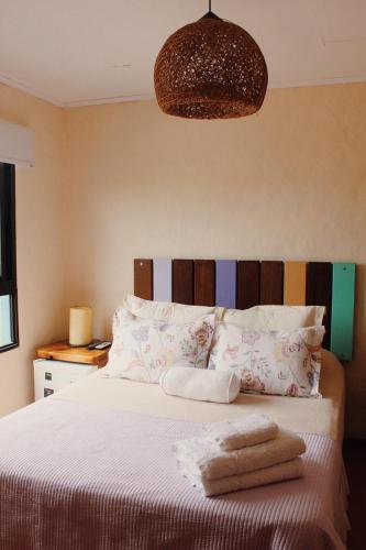 a bedroom with a bed with two towels on it at Posada de la Viuda in Punta Del Diablo