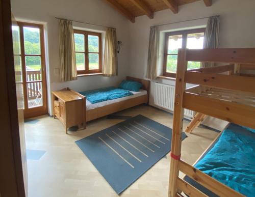 a bedroom with a bunk bed and two windows at Ferienwohnungen Wolfgang Geistanger in Siegsdorf