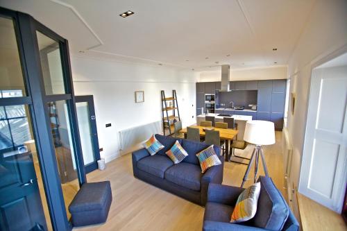 a living room with two couches and a dining room at Northlight Apartments - The Lookout in Kirkwall