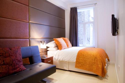 a bedroom with a bed and a couch and a window at City Inn Russell Square in London