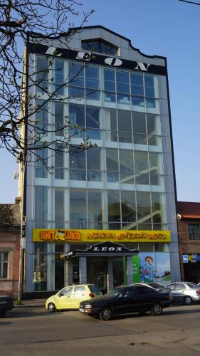 a tall glass building with cars parked in front of it at City Hostel Panorama in Uzhhorod