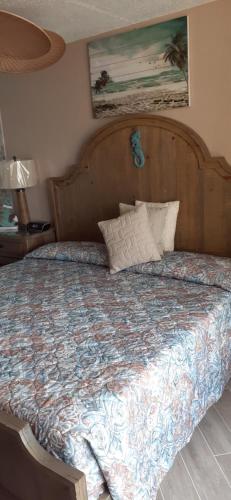 a bed with a wooden headboard in a bedroom at Daytona Beach Hawaiian Inn in Daytona Beach