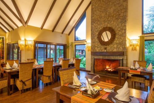 a dining room with tables and a fireplace at The Retreat at Ngorongoro in Karatu