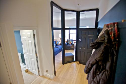 a room with a hallway with a door and a mirror at Northlight Apartments - The Lookout in Kirkwall