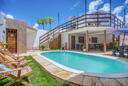 a swimming pool in the backyard of a house at Convés Pousada in Barra de São Miguel