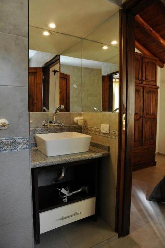a bathroom with a sink and a large mirror at Cabanias El Aguaribay in San Javier