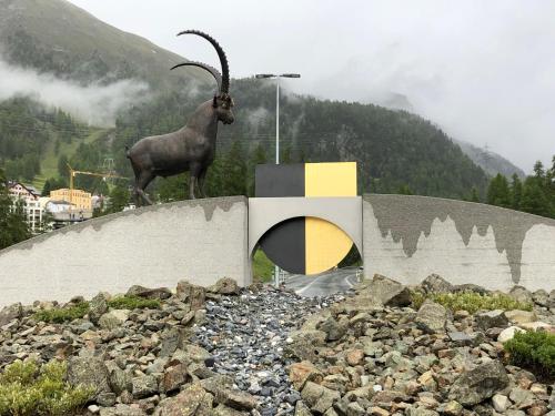 a statue of a goat standing on top of a wall at Ferienwohnung Pontresina - Chesa Andrea - Gartensitzplatz in Pontresina