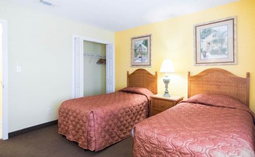 a hotel room with two beds and a mirror at GetAways at Soundside Holiday Beach Resort in Pensacola Beach
