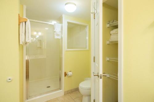 a bathroom with a toilet and a glass shower at GetAways at Soundside Holiday Beach Resort in Pensacola Beach