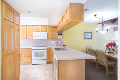 a kitchen with wooden cabinets and white appliances at GetAways at Soundside Holiday Beach Resort in Pensacola Beach