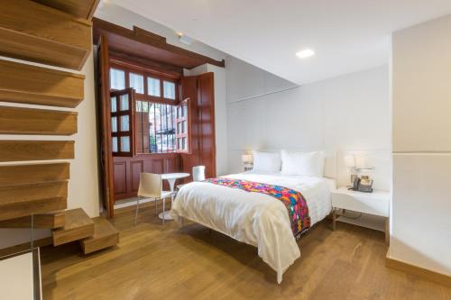 um quarto com uma cama, uma secretária e uma janela em Domingo Santo Hotel Boutique em Cidade do México