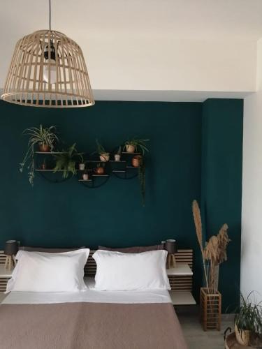 a bedroom with a green wall with a bed and potted plants at La Terrazza di Empedocle in Agrigento