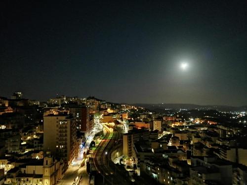 a view of a city at night with the moon at La Terrazza di Empedocle in Agrigento