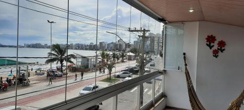 einen Balkon mit Blick auf die Stadt und eine Straße in der Unterkunft Apartamento BEIRA MAR TOTAL-PÉ NA AREIA -VISTA TOTAL PARA O MAR - ÁREA DE CHURRASCO PRIVATIVA- TODAS TVS SMART- MÁQUINA DE CAFÉ -AIR FRYER -NETFLIX -DISNEY PLUS -STARMAX- HBO MAX ASSINADOS - JOGOS- FIRE TV STICK AMAZON- GELADEIRA EXTRA PARA BEBIDAS in Guarapari