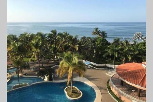 Blick auf ein Resort mit Pool und Meer in der Unterkunft Departamento Carabelas de Colón in Playas