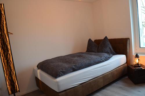 a bedroom with a bed with a brown blanket at Guesthouse Meitschi Thun - contactless self check-in in Thun