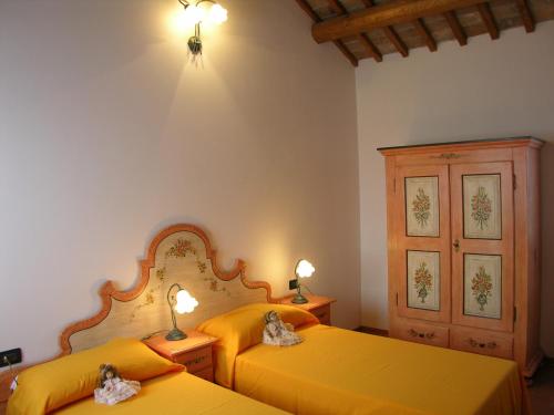 キオッジャにあるAgriturismo Zennareの黄色いシーツが備わる客室内のベッド2台