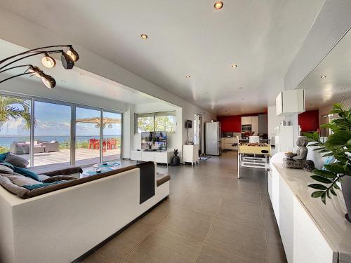 a kitchen and living room with a view of the ocean at Villa SEA VIEW, 5 min from the beach, overlooking the caribbean sea, private pool in Friar's Bay