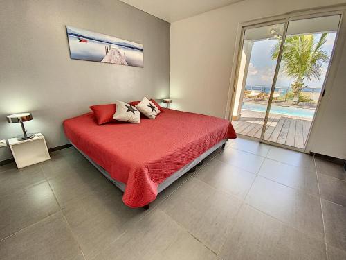 a bedroom with a bed with a view of the ocean at Villa SEA VIEW, 5 min from the beach, overlooking the caribbean sea, private pool in Friar's Bay