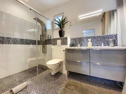 a bathroom with a toilet and a glass shower at Villa SEA VIEW, 5 min from the beach, overlooking the caribbean sea, private pool in Friar's Bay