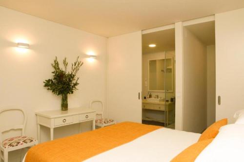 a bedroom with a bed and a bathroom with a sink at Hotel Casa Palmela - Small Luxury Hotels of The World, Hotel & Villas in Setúbal