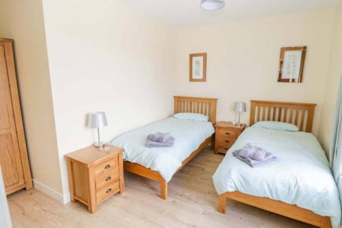 two beds in a room with two night stands and two lamps at John & Margarets Place in Ballinamore