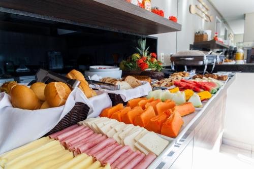 un buffet garni de différents types de fromages et de pains dans l'établissement Pousada Praia de Porto, à Porto de Galinhas