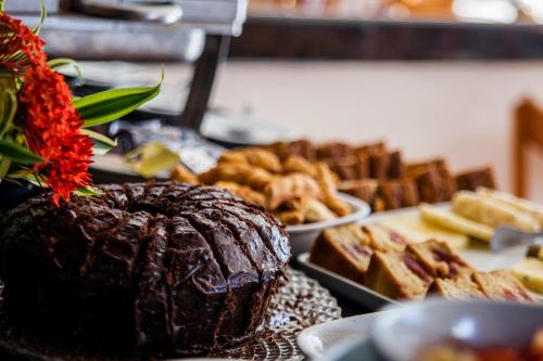 une table garnie d'un gâteau au chocolat et d'autres pâtisseries dans l'établissement Pousada Praia de Porto, à Porto de Galinhas
