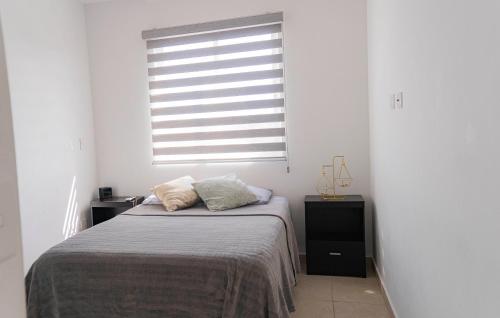 a bedroom with a bed and a window at CASA EN PRIVADA FRENTE A LA PLAYA CON ALBERCA! in Mazatlán