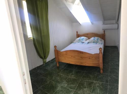 a small bedroom with a wooden bed with a window at Tropic Arth Paradise in Port-Louis